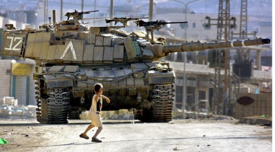 ایک فلسطینی بچہ اسراییلی ٹینک پر پتھر پھینکتے ہوے۔